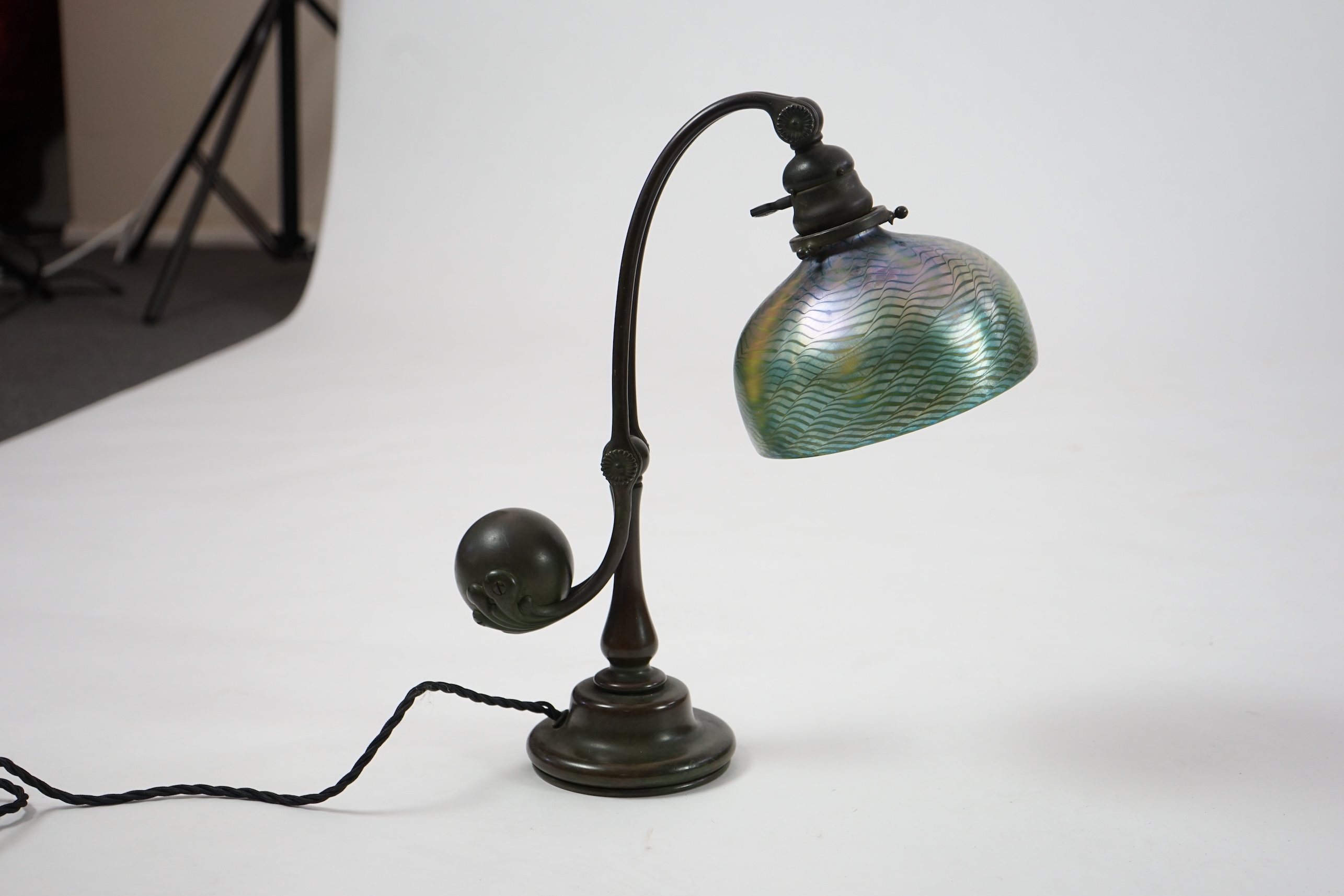 Tiffany Studios. A patinated bronze counter-balance desk lamp with ‘favrile’ glass shade, c.1905